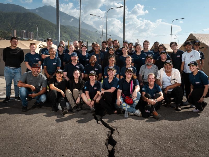 Members of the UK Emergency Medical Team assembled for a group photograph in front of the Type 1 Plus field hospital in La Guaira, Venezuela.